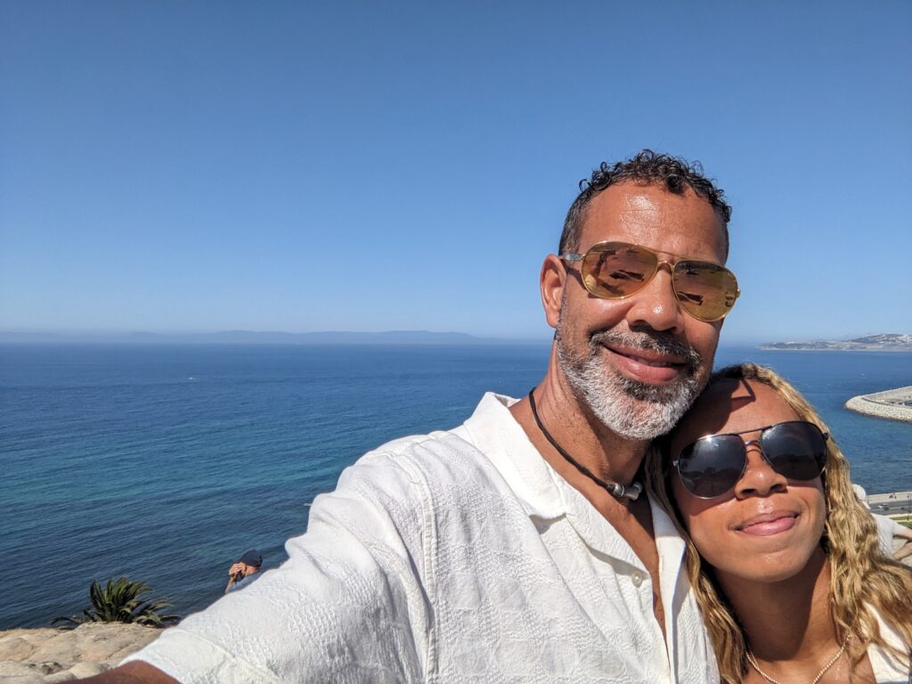 Scott Saffold and his wife at a scenic ocean.